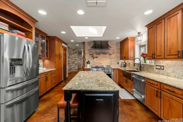 a kitchen with granite countertop white cabinets and a sink