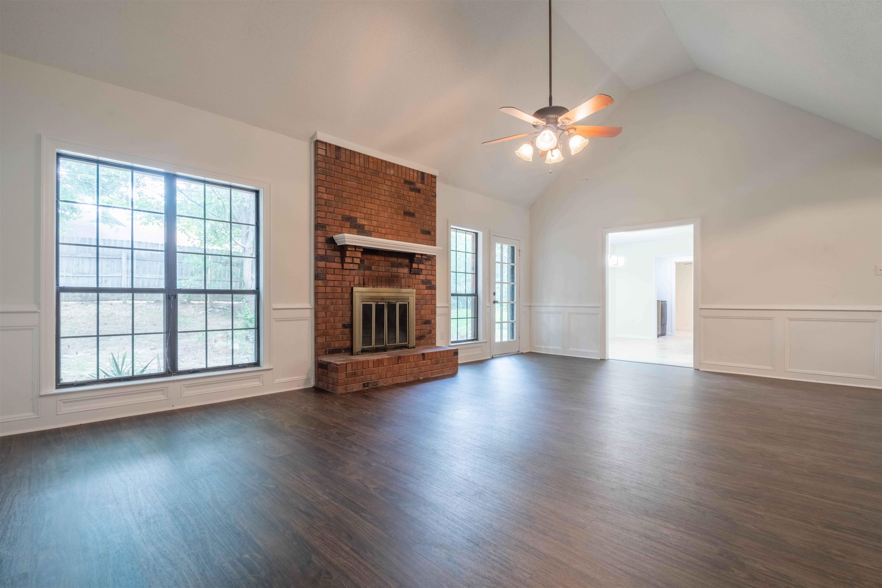7800 Buck Ridge Cove Memphis, TN 38016 - Photo 9 of 36 Spacious living area featuring a vaulted ceiling, wood-finish flooring, and white wainscoting