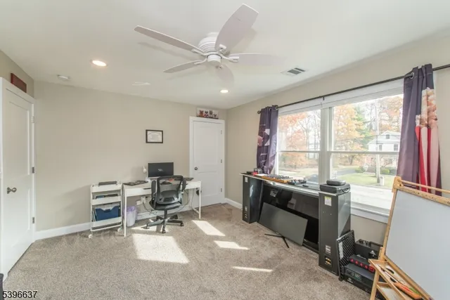a view of a workspace with furniture and a window