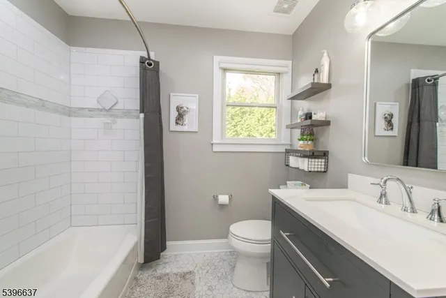 a bathroom with a bathtub toilet sink vanity and windows