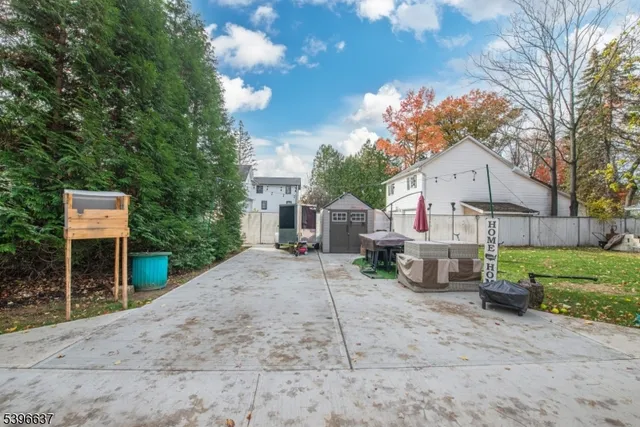 a view of a house with a yard and a large tree