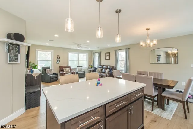 a living room with stainless steel appliances kitchen island a table and chairs