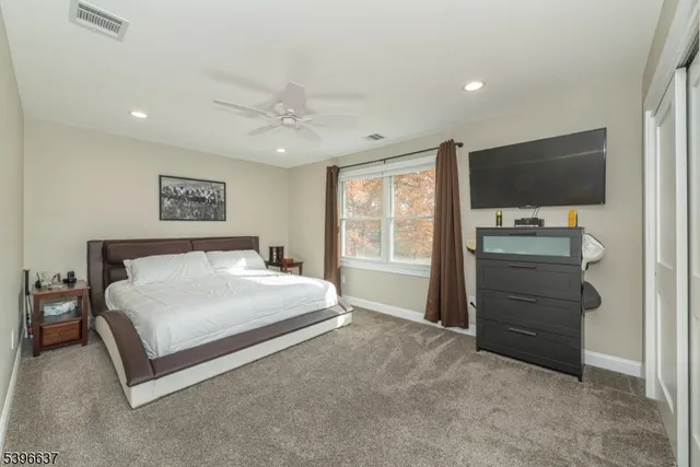 a spacious bedroom with a bed and a flat screen tv