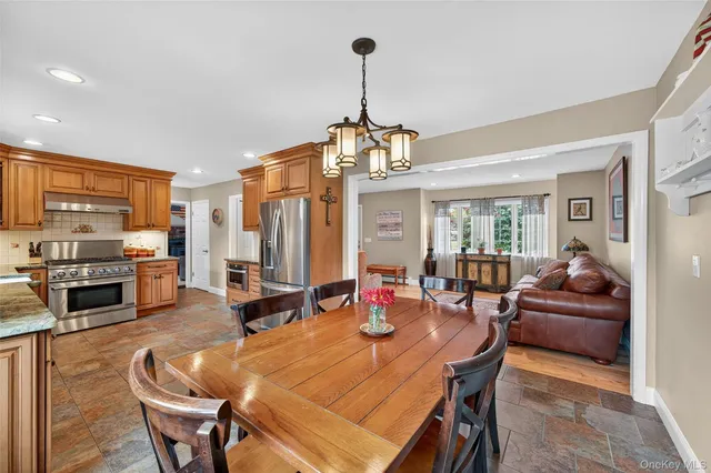 a dining room with a table chairs and a kitchen view