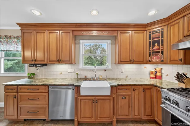 a kitchen with stainless steel appliances granite countertop a stove sink and cabinets