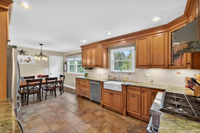 a kitchen with stainless steel appliances granite countertop a sink stove and cabinets