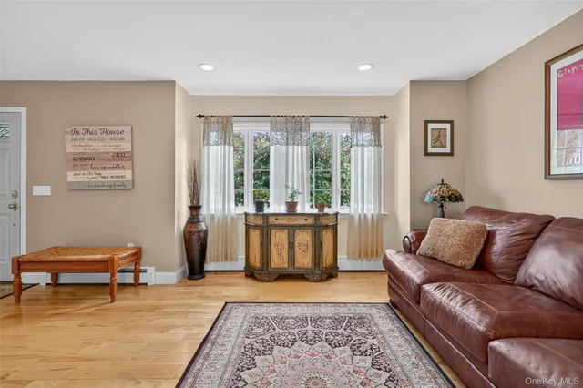 a living room with furniture and a dresser with wooden floor