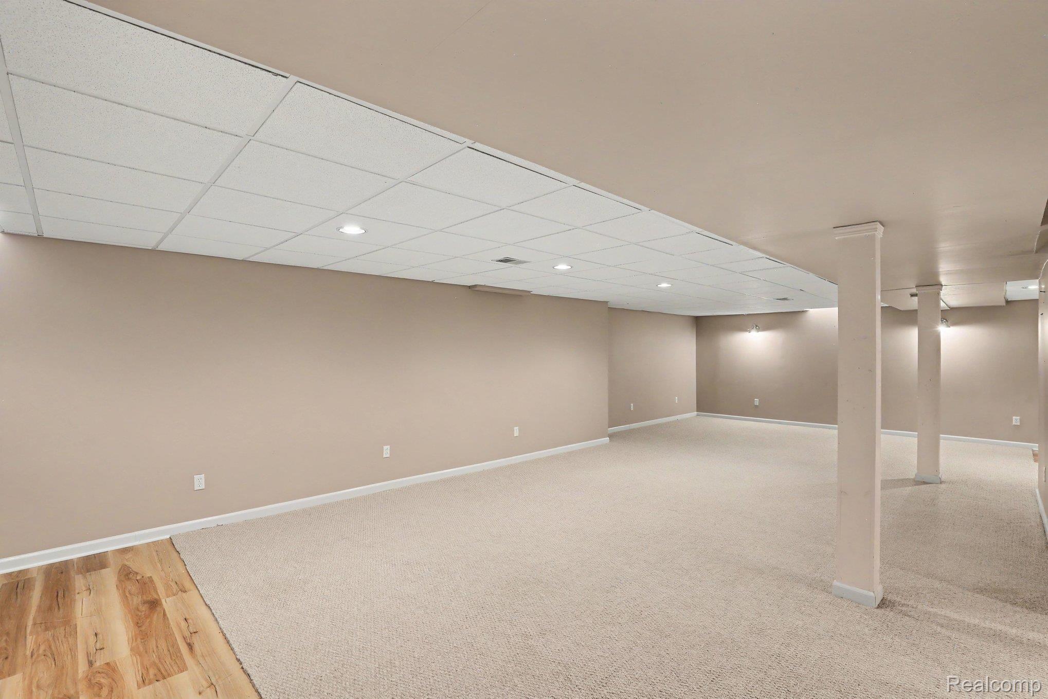 34917 Chickadee Ridge Richmond, MI 48062 - Photo 18 of 32 Expansive finished lower level featuring recessed lighting, a drop ceiling, neutral carpeting, and a wood-finish flooring accent