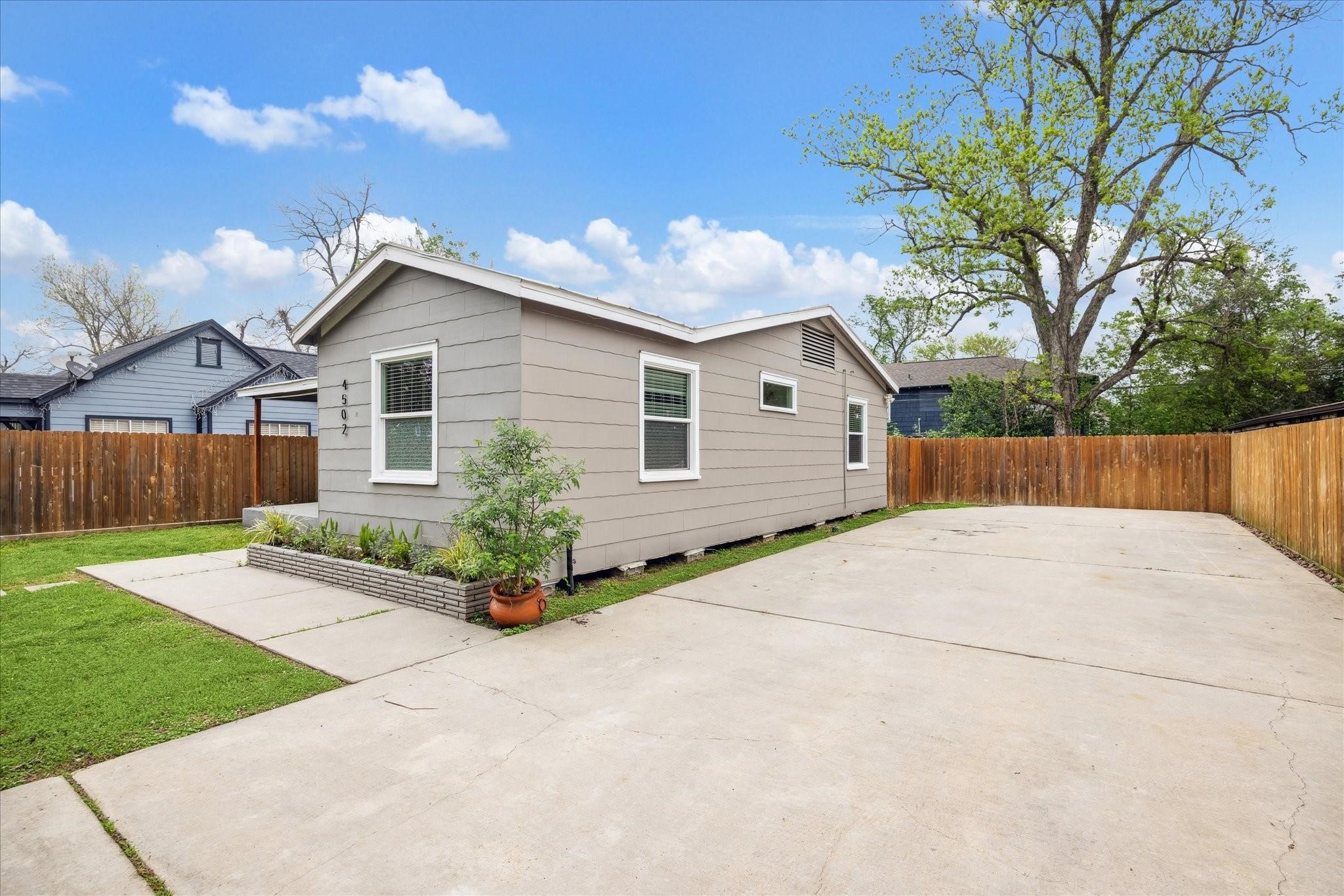 a view of a house with a yard and potted plants