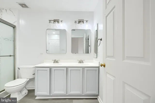 a bathroom with a toilet a sink and mirror