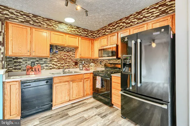 a kitchen with stainless steel appliances granite countertop a refrigerator and a sink