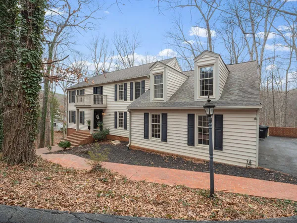 a front view of a house with a tree