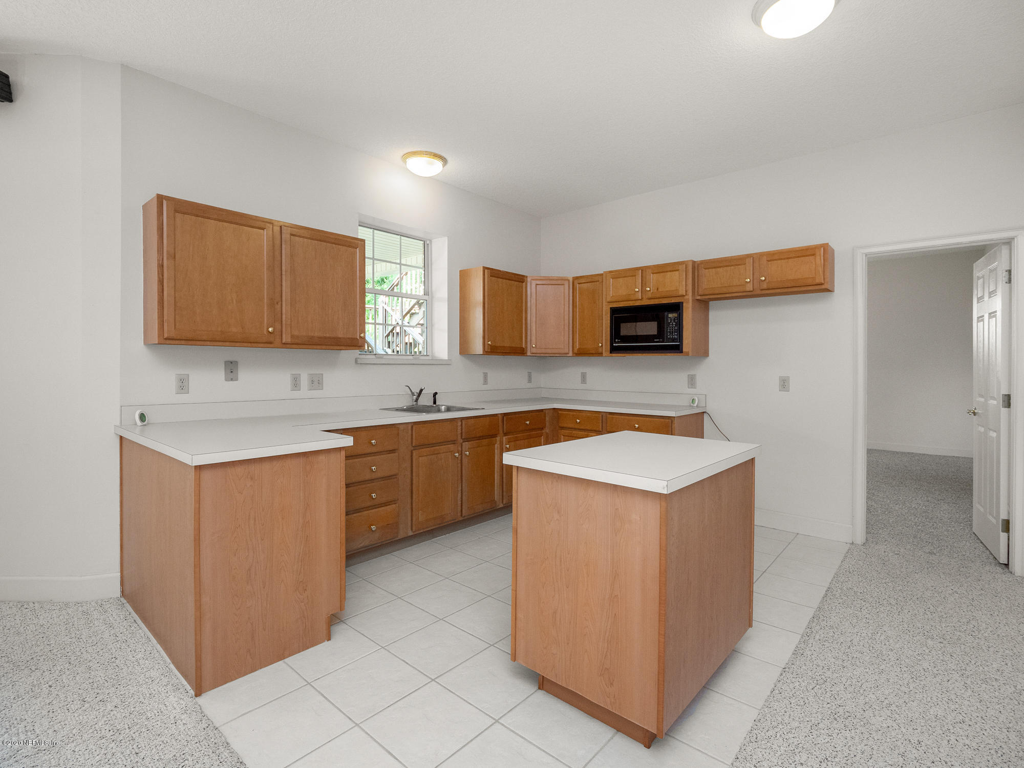 3664 Spinnaker Court Jacksonville, FL 32277 - Photo 27 of 42 a kitchen with a stove top oven a sink a refrigerator and a microwave