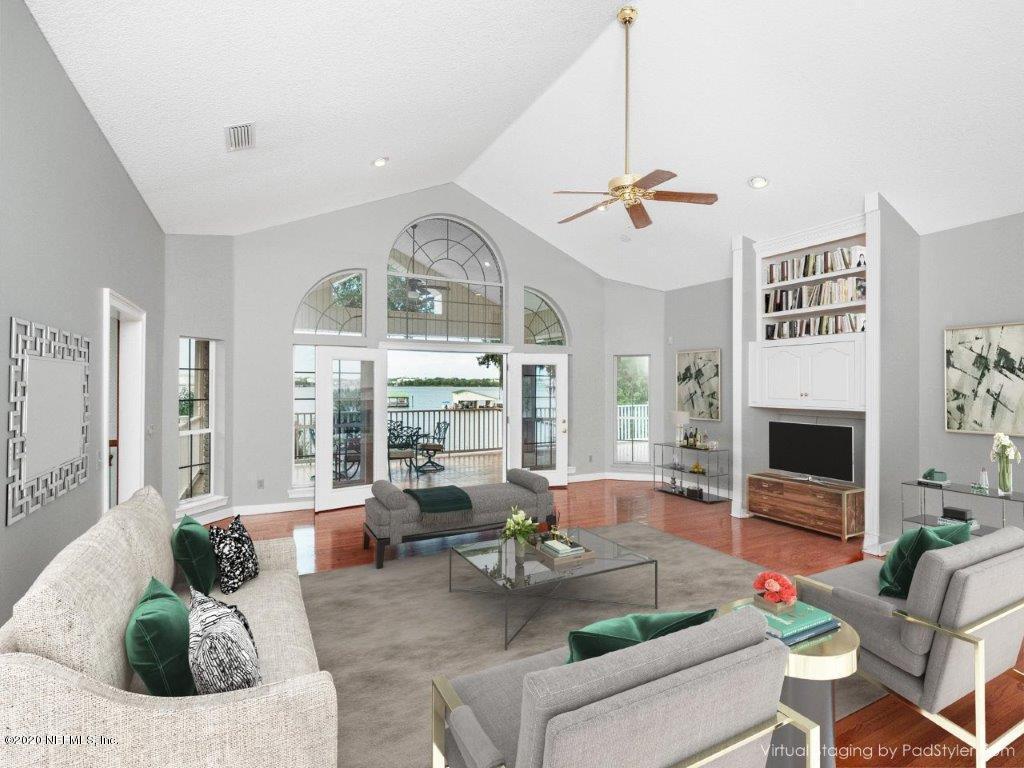 3664 Spinnaker Court Jacksonville, FL 32277 - Photo 7 of 42 a living room with furniture a fireplace and a chandelier