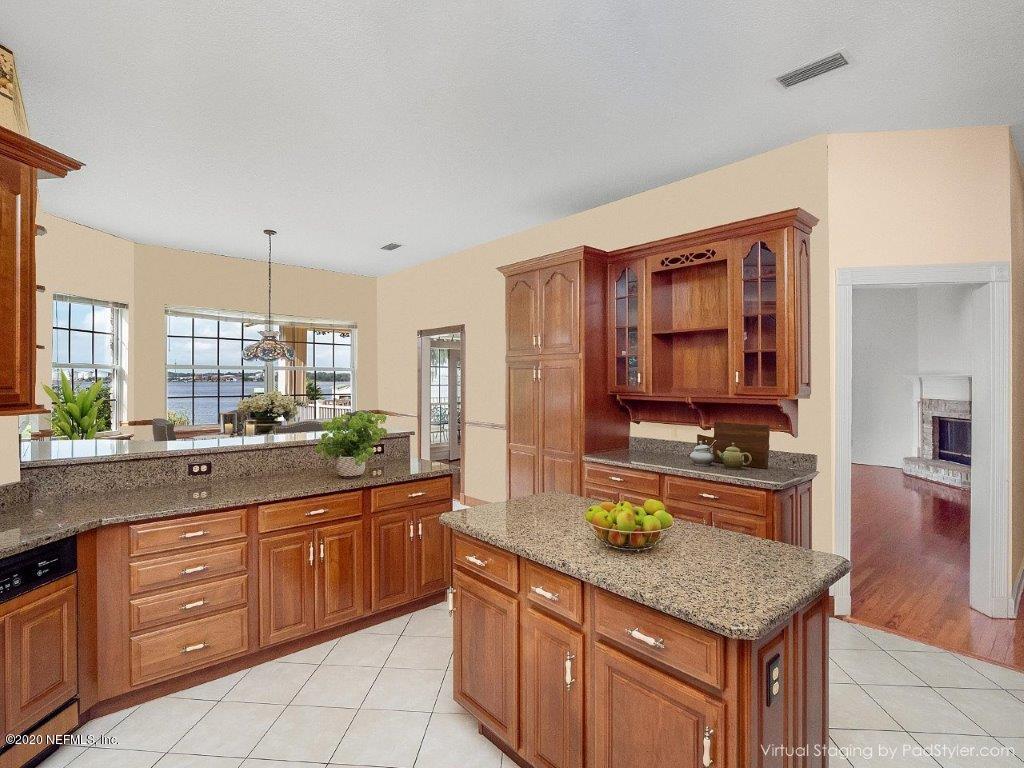 3664 Spinnaker Court Jacksonville, FL 32277 - Photo 10 of 42 a kitchen with stainless steel appliances granite countertop wooden cabinets a stove a sink and a wooden floors