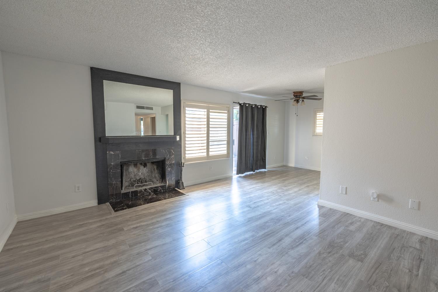 3700 Tully Road, Unit 5 Modesto, CA 95356 - Photo 5 of 38 an empty room with wooden floor fire place and windows