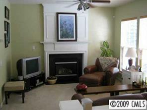 14054 Dingess Road Charlotte, NC 28273 - Photo 5 of 8 a living room with furniture a flat screen tv and a fireplace