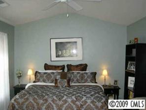 14054 Dingess Road Charlotte, NC 28273 - Photo 6 of 8 a bedroom with a bed and a lamp on dresser