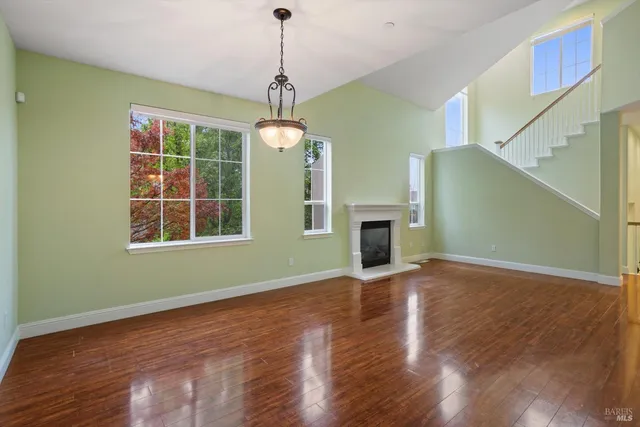 a view of an empty room with window wooden floor and fire place