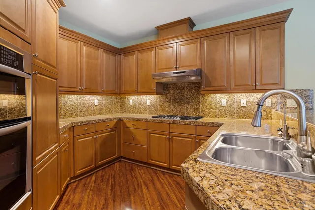 a kitchen with stainless steel appliances granite countertop a sink stove and cabinets
