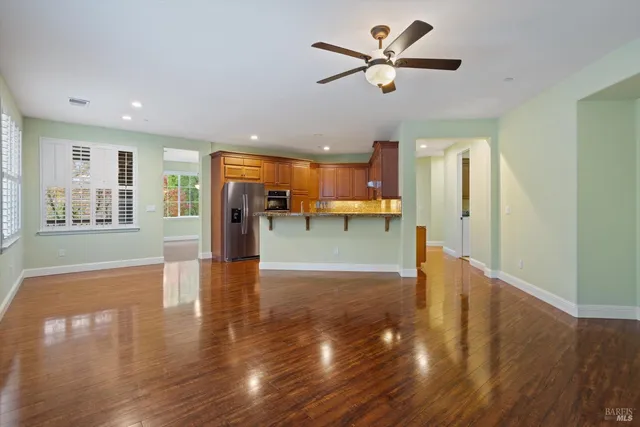 a view of a big room with wooden floor and a kitchen