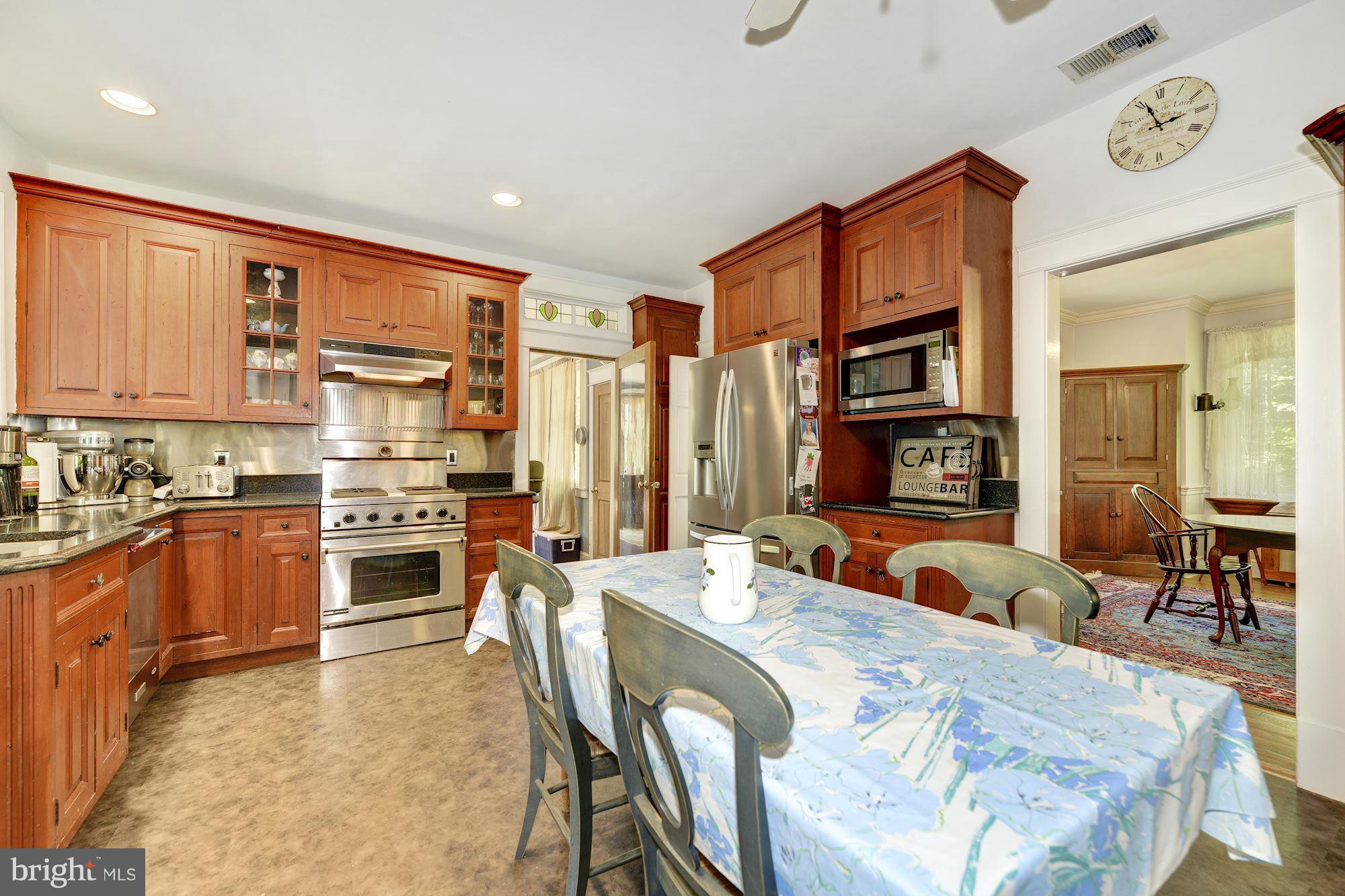 4011 Gallows Road Annandale, VA 22003 - Photo 9 of 27 a large kitchen with stainless steel appliances granite countertop a stove a sink a dining table and chairs