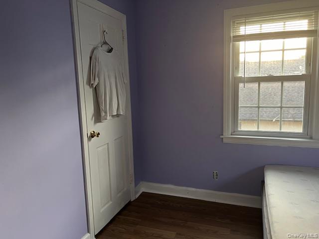225 Thompson Shore Road, Unit 2F Manhasset, NY 11030 - Photo 5 of 15 an empty room with wooden floor and windows