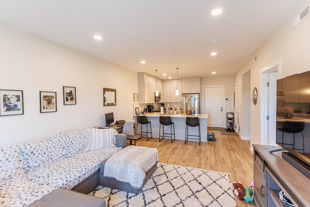 458 Washington Street, Unit 304 Boston, MA 02135 - Photo 2 of 13 a living room with furniture flat screen tv and a table