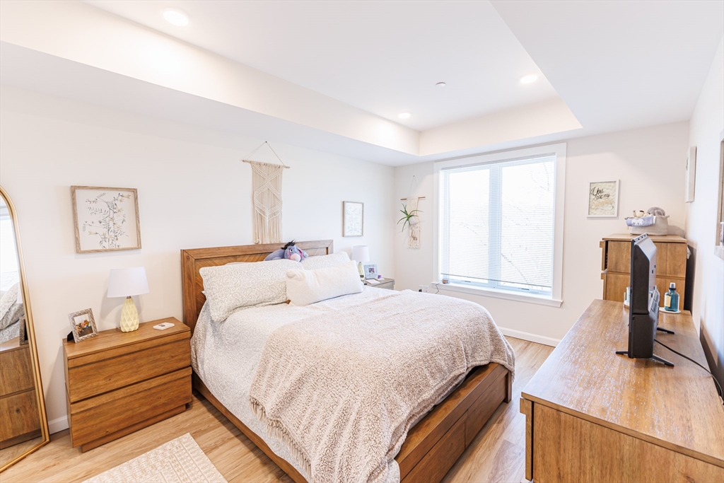 458 Washington Street, Unit 304 Boston, MA 02135 - Photo 6 of 13 a bedroom with a bed and wooden floor