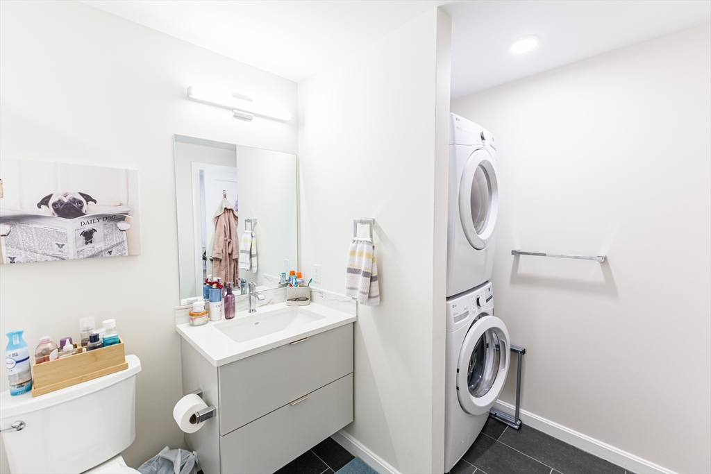 458 Washington Street, Unit 304 Boston, MA 02135 - Photo 9 of 13 a bathroom with a sink mirror washer and dryer
