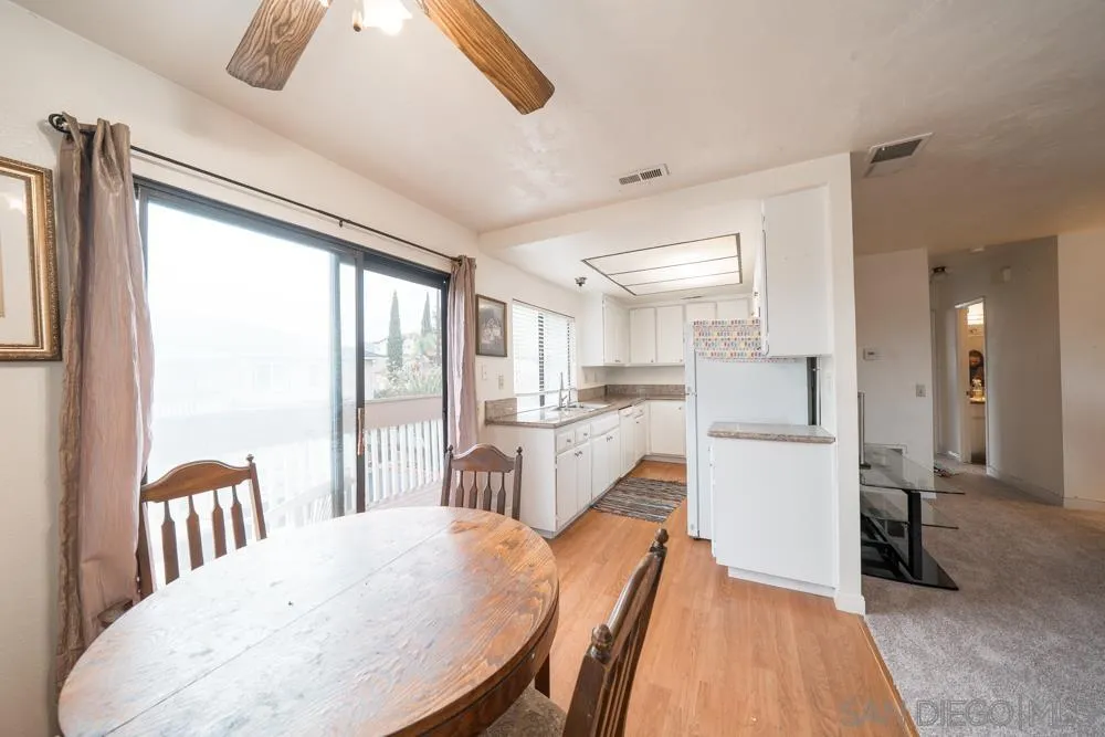7967 Arly Court, Unit 24 Santee, CA 92071 - Photo 16 of 25 a kitchen with stainless steel appliances a refrigerator a sink dishwasher and a dining table with wooden floor