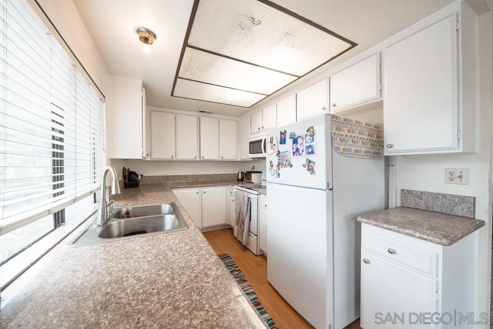 7967 Arly Court, Unit 24 Santee, CA 92071 - Photo 17 of 25 a kitchen with stainless steel appliances granite countertop a refrigerator sink and white cabinets
