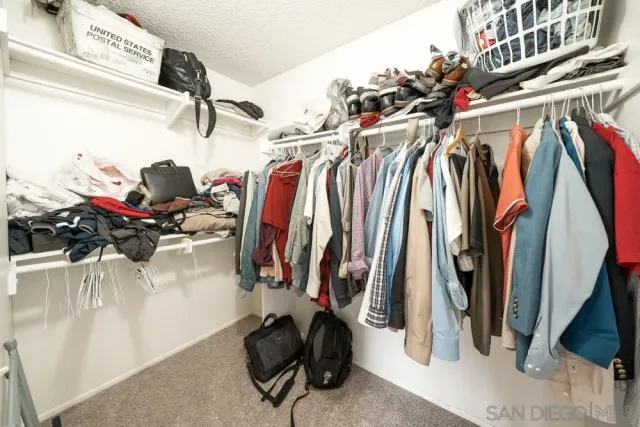 a view of walk in closet with clothes and shoes
