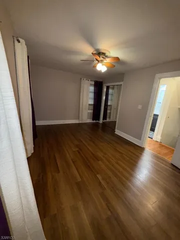 a view of hallway with stairs and wooden floor