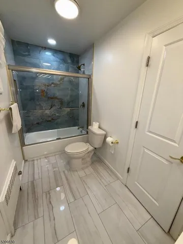 a bathroom with a toilet and a shower
