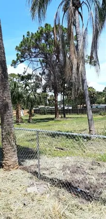 a view of a yard with wooden fence