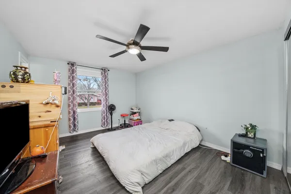 a bedroom with a bed and wooden floor