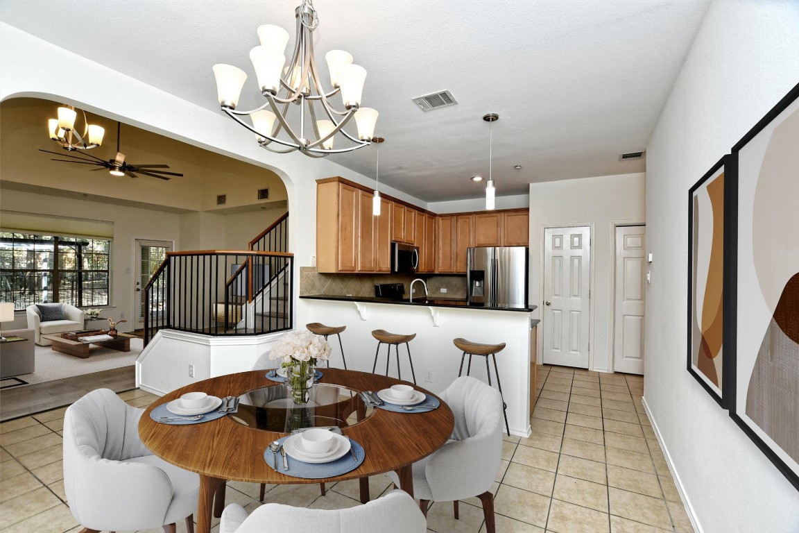 1310 West Parmer Lane, Unit 2803 Austin, TX 78727 - Photo 16 of 40 a view of a dining room with furniture and a chandelier