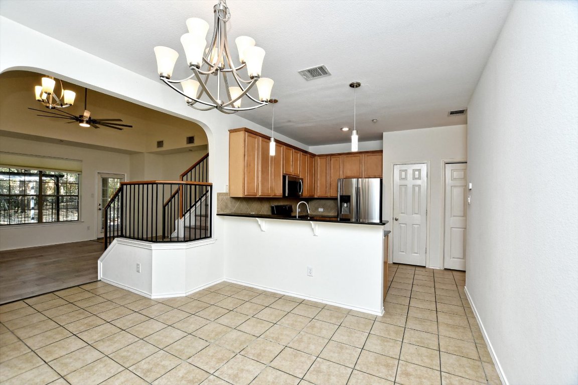 1310 West Parmer Lane, Unit 2803 Austin, TX 78727 - Photo 17 of 40 a view of a hallway with wooden floor and chandelier