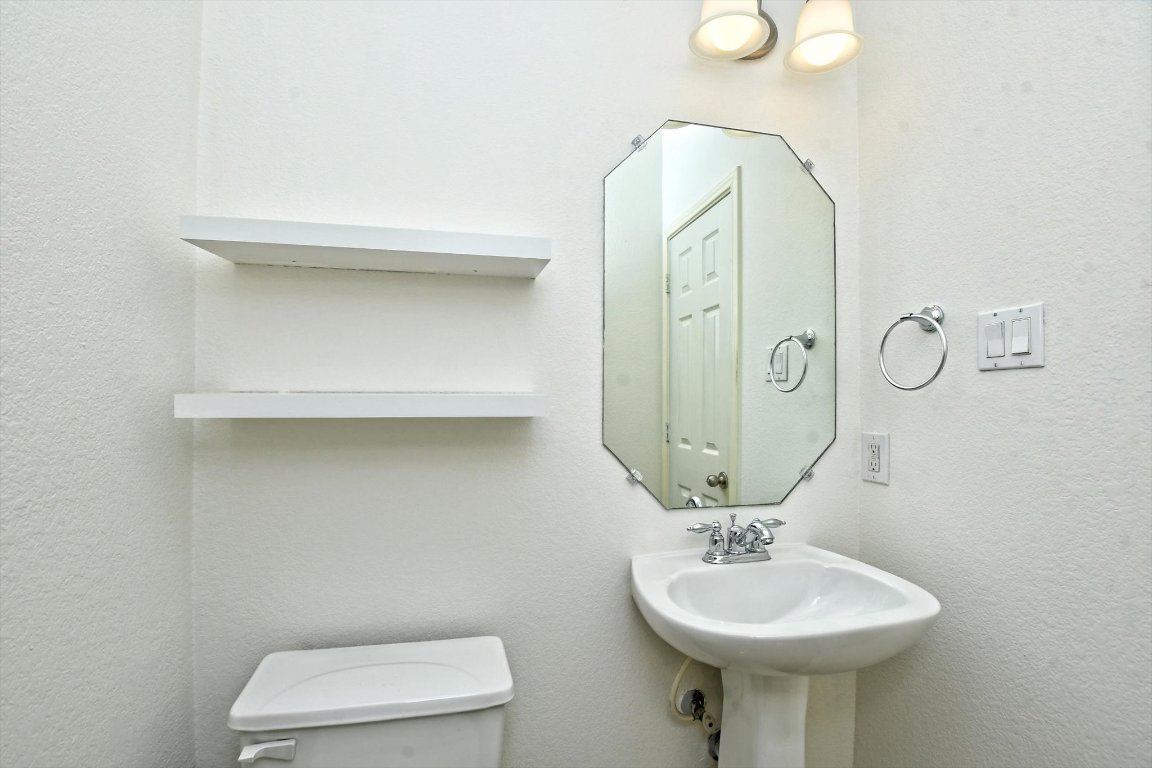 1310 West Parmer Lane, Unit 2803 Austin, TX 78727 - Photo 20 of 40 a bathroom with a sink a toilet and mirror