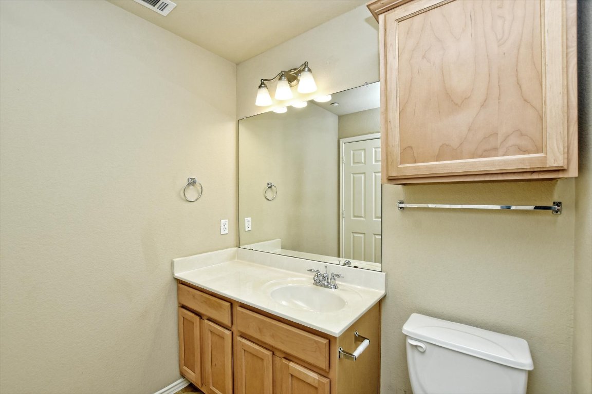 1310 West Parmer Lane, Unit 2803 Austin, TX 78727 - Photo 30 of 40 a bathroom with a sink vanity mirror and toilet