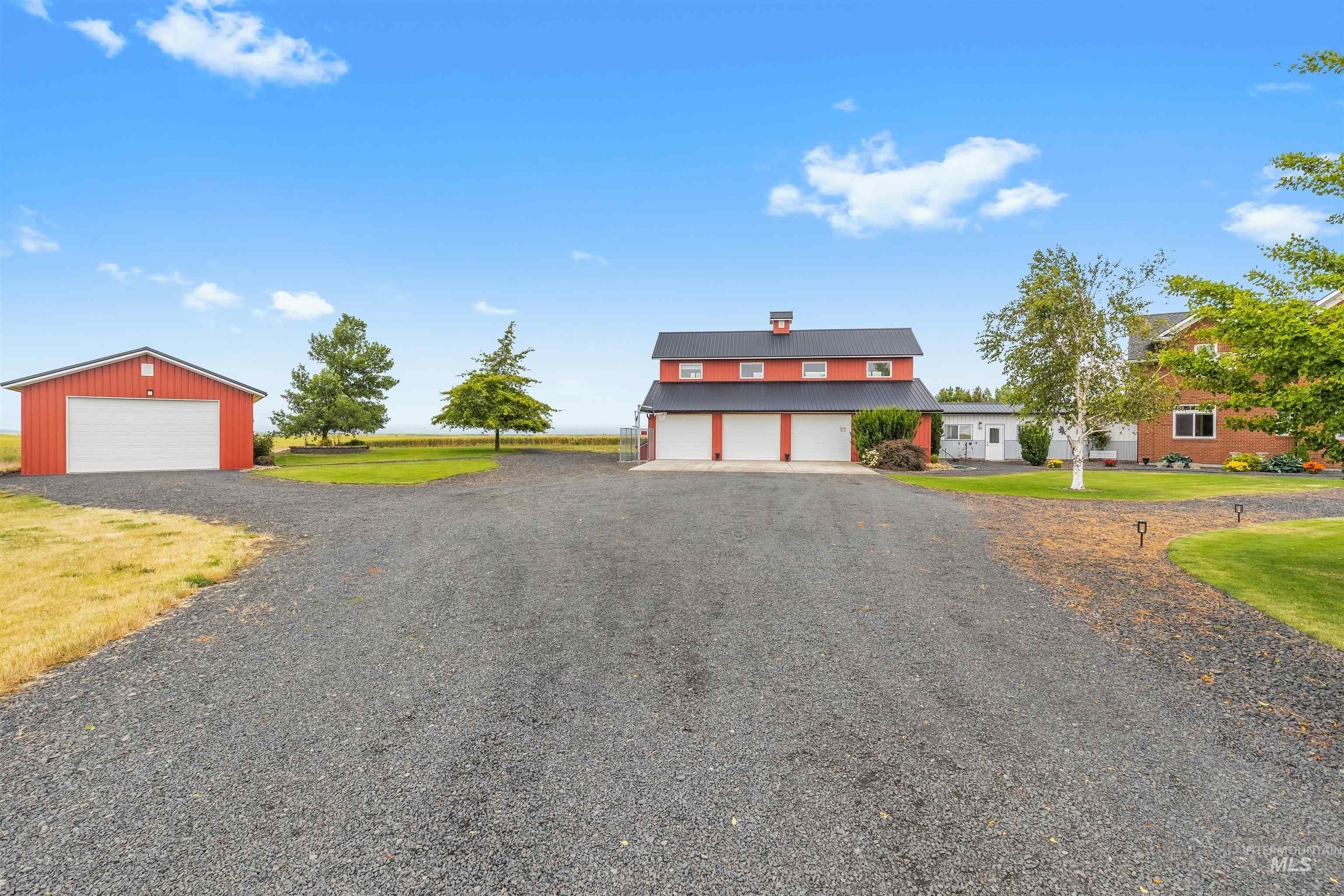 1513 Uniontown Road Genesee, ID 83832 - Photo 49 of 50 Expansive yellow field surrounding a residence with a dark exterior, multiple gables, and prominent white-framed windows