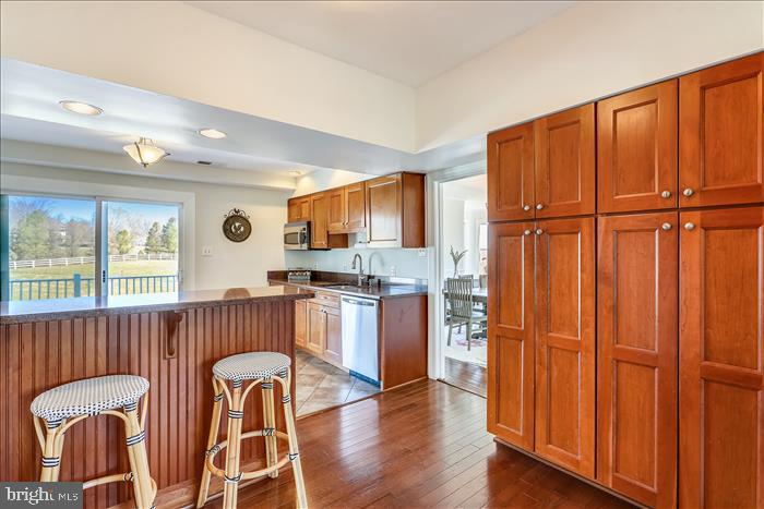 9333 Watkins Road Gaithersburg, MD 20882 - Photo 13 of 65 a kitchen with stainless steel appliances granite countertop a refrigerator a stove top oven a sink dishwasher and wooden cabinets with wooden floor