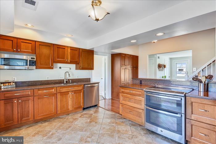9333 Watkins Road Gaithersburg, MD 20882 - Photo 15 of 65 a large kitchen with stainless steel appliances granite countertop a stove and cabinets