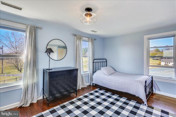 9333 Watkins Road Gaithersburg, MD 20882 - Photo 36 of 65 a bedroom with a bed a mirror on the dresser and a large window