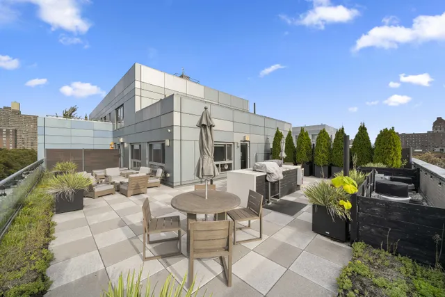 a view of a patio with couches table and chairs under an umbrella