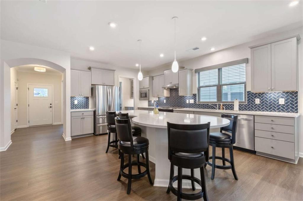 5213 Morrell Road Hoschton, GA 30548 - Photo 13 of 49 a kitchen with a table chairs refrigerator and cabinets