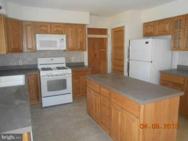 7384 Station Road Newcomb, MD 21653 - Photo 7 of 10 a kitchen with stainless steel appliances granite countertop a stove a sink and a refrigerator