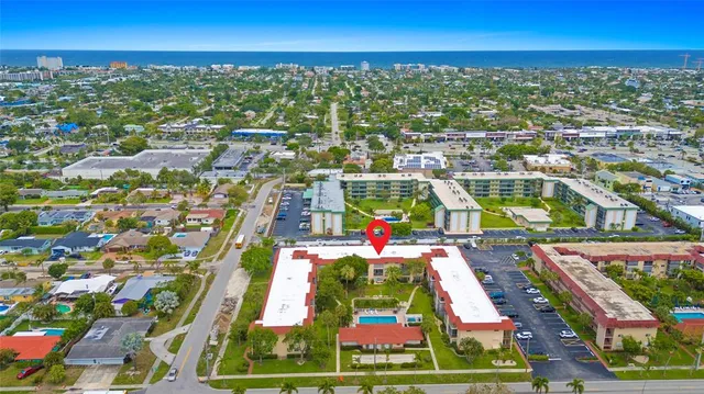 an aerial view of residential houses with outdoor space and ocean view