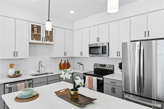 a kitchen with stainless steel appliances a sink a stove and refrigerator